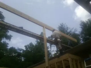 Carpenter setting a ridge beam over a new addition frame — Ice Dam Removal by Roofing Brothers in La Habra