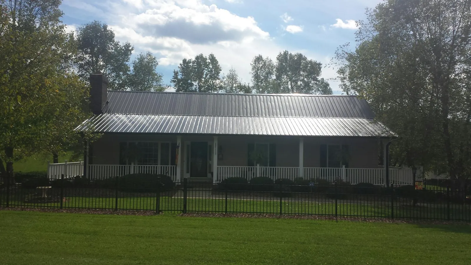 Gray metal roof on a brick ranch with a full width front porch — Gutter Guard Installation work by our crew in La Habra